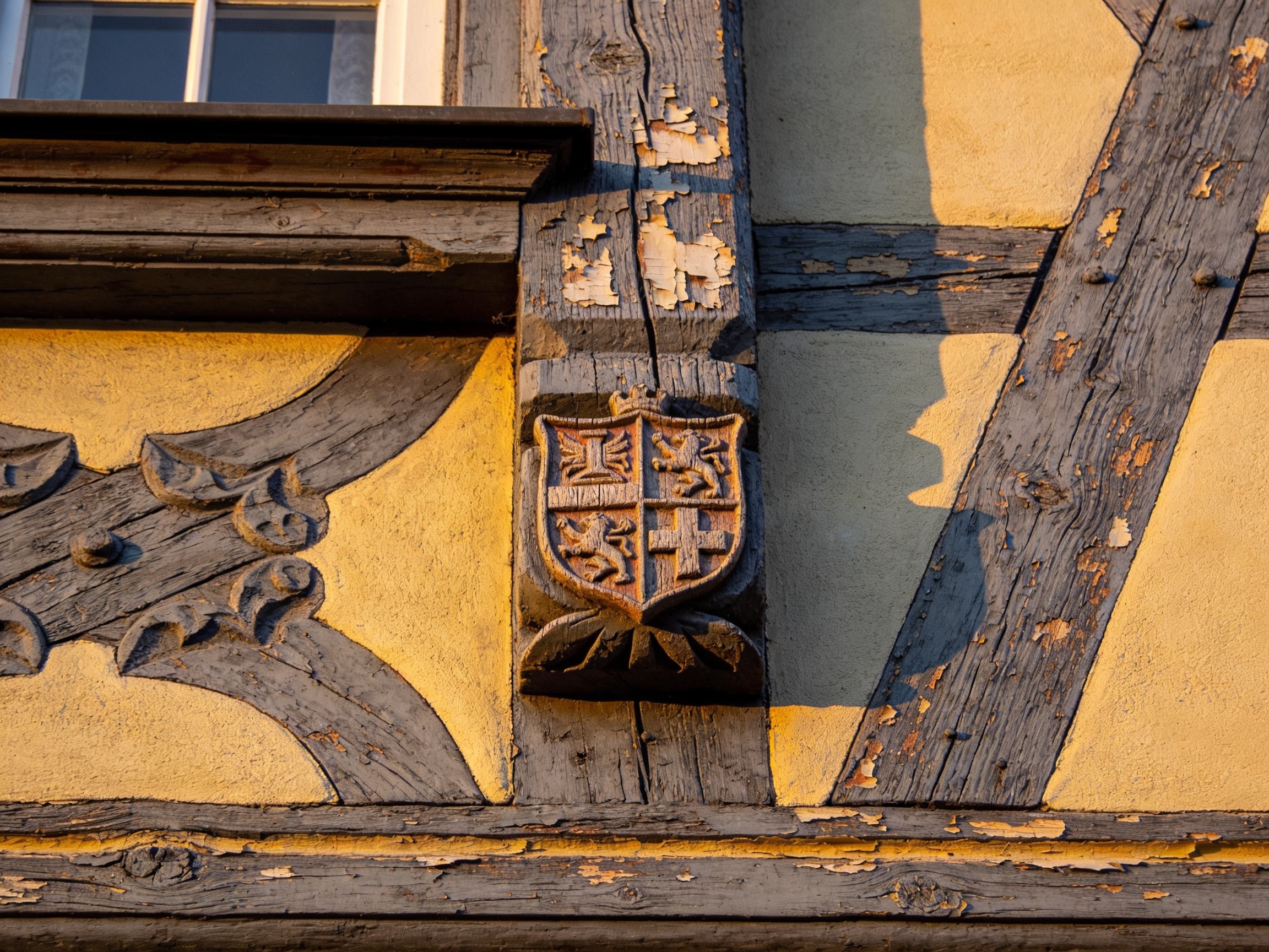 Detail einer Fachwerkfassade mit heraldischem Schild in der Friedberger Altstadt